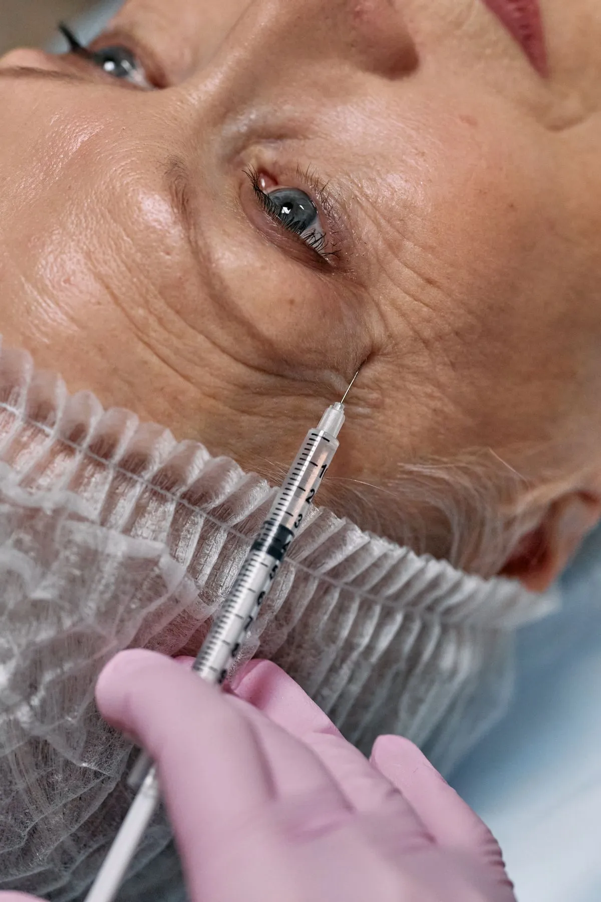 A practitioner carrying out a careful, precise treatment on a calm patient